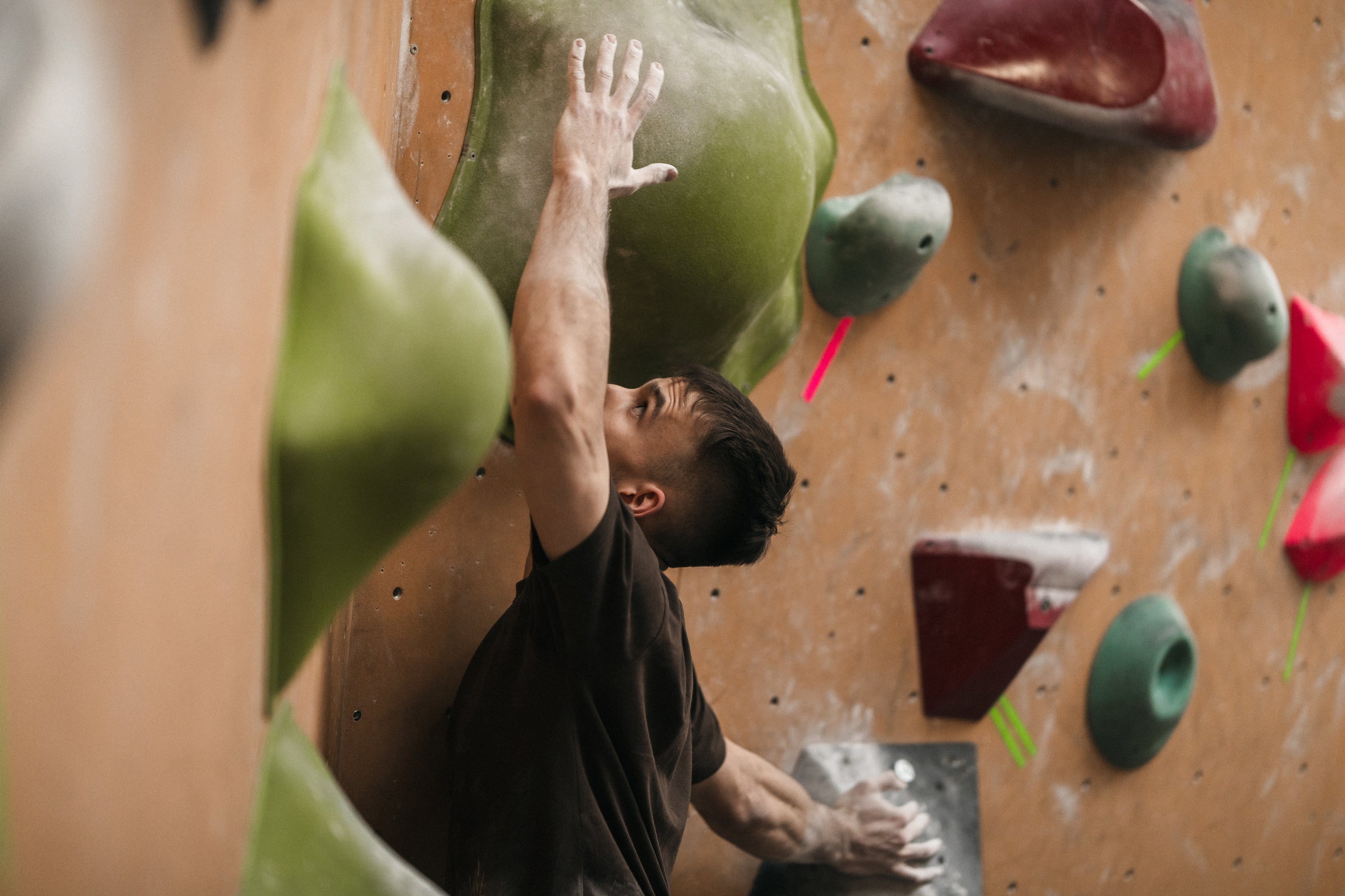 Mężczyzna wspinający się na zawodach boulderowych